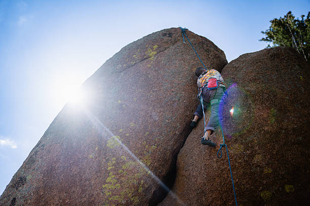 Low-angle view looking up at a man rock climbing a crack at Vedauwoo Recreation Area in Wyoming on a sunny summer day.