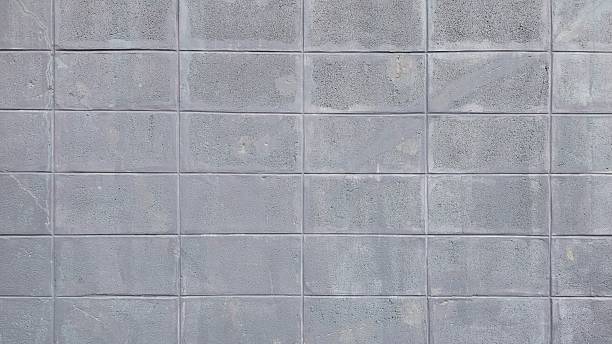 istock Old gray brick wall is cracked, the paint is peeling off, damaged and has stains. 2226133029