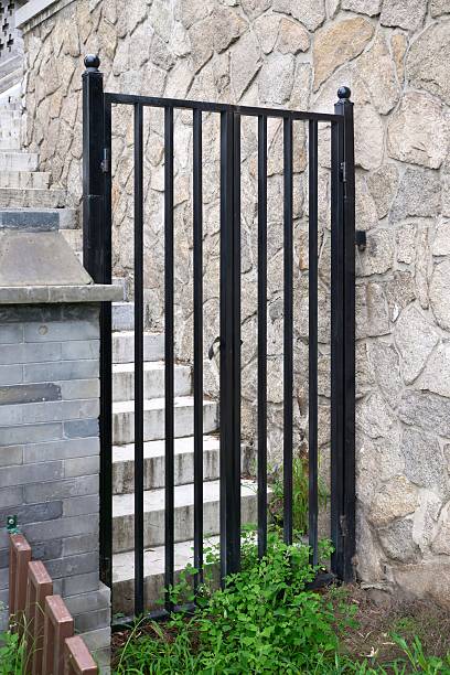 istock A black gate with a stone wall in the background 2226133932