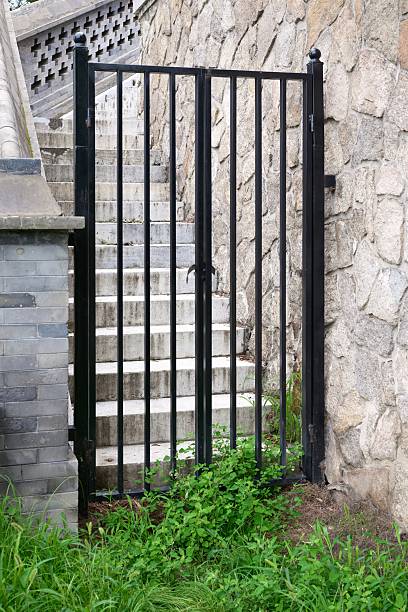 A gate with a staircase in front of it. The gate is open and the stairs are closed