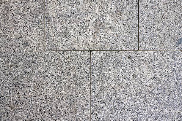 A gray and white tile floor with a pattern of squares. The tiles are not very large, and the pattern is not very intricate. The floor appears to be made of stone or concrete