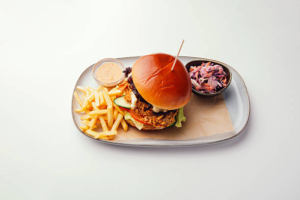 A delicious burger with crispy fries and refreshing coleslaw beautifully arranged on a plate