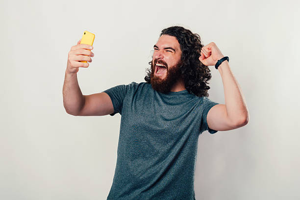 istock A joyful man is celebrating triumphantly while holding a smartphone in his hands 2226141017