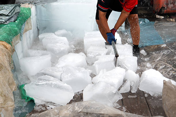 istock A person skillfully using a sharp axe to chop and break apart large frozen blocks of ice outdoors. 2226141702