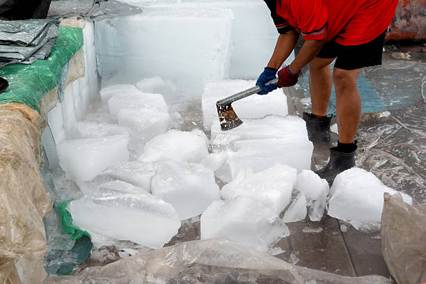 istock A person skillfully using a sharp axe to chop and break apart large frozen blocks of ice outdoors. 2226141710