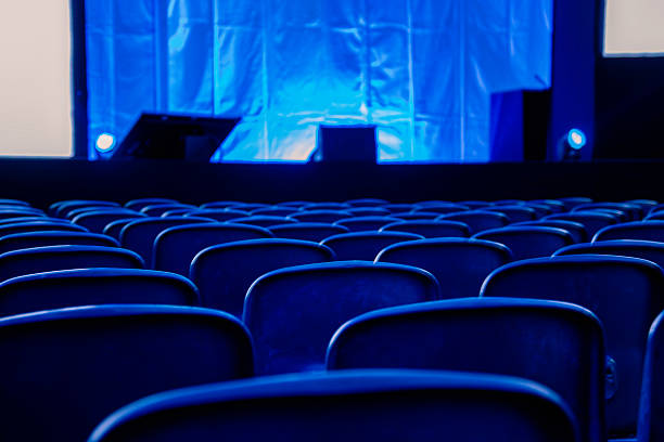 Empty seats in auditorium or theater with lights on stage. Business conference.