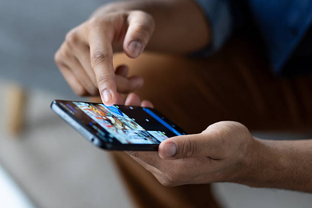 istock Close-up of a hand interacting with a smartphone, engaged in digital activity. 2226145804