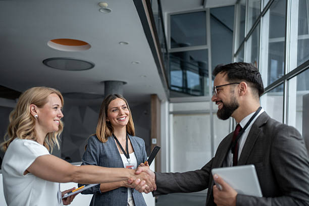 istock Businesspeople shaking hands at a conference 2226146561