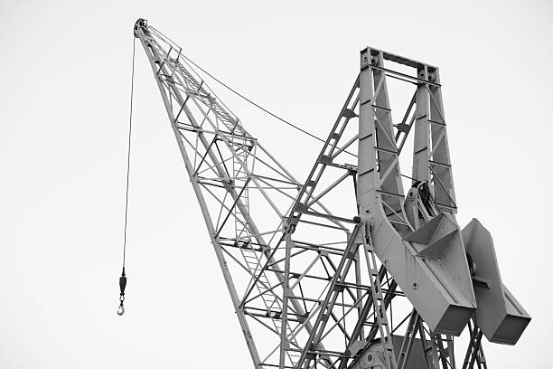 Harbor crane, in black and white, at a commercial port awaiting its next shipment.