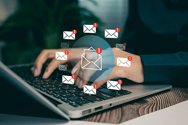 istock Email notification alert concept. Hands typing on laptop keyboard surrounded by digital envelope icons with unread message alerts. 2226149348