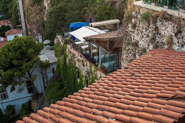 This vibrant hillside showcases rustic rooftops adorned with terracotta tiles, surrounded by lush greenery and charming architecture at sunset.