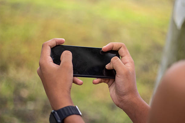 istock A man holds a mobile phone with his both hands, and the background is blurred 2226152575