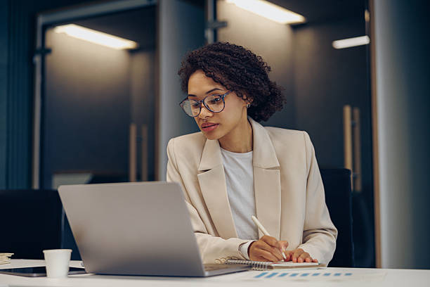 istock Focused female freelancer in eyeglasses working on laptop while sitting in modern coworking 2226157730