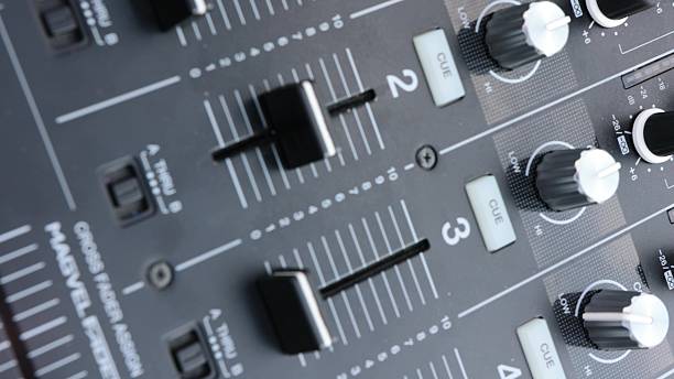 Close-up of a professional audio mixer's faders and knobs, conveying precision, control, sound engineering, and the process of creating impactful auditory experiences.