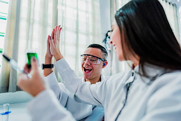 istock Students celebrating with high-five while carrying out scientific experiment in the laboratory 2226161369