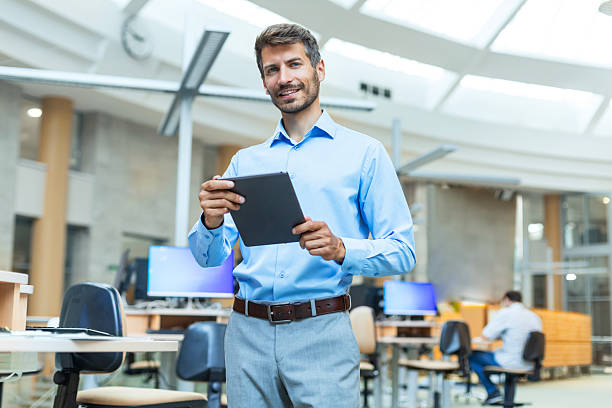 istock Modern business man in formalwear using digital tablet while standing in the office 2226162916