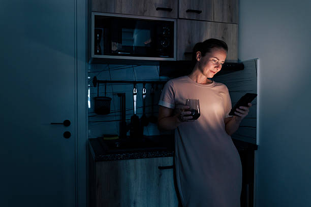 istock Woman taking online course class using smart phone while relaxing at home at night 2226165513