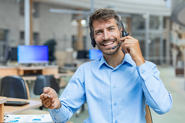 istock Portrait of man call center agent operator working in a creative office, for online support, in video call with headphones looking at camera 2226166897
