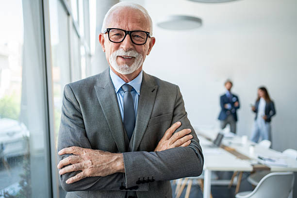 istock Senior businessman smiling with folded arms in modern office 2226169320