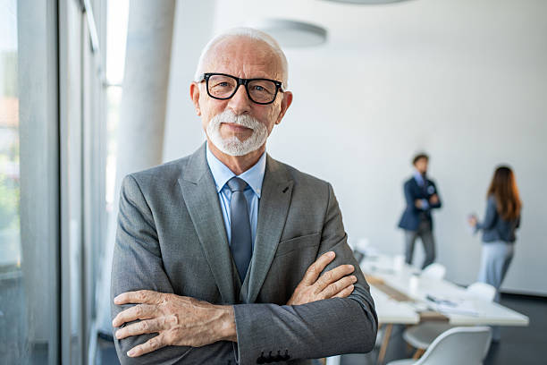 istock Senior businessman smiling with folded arms in modern office 2226169399