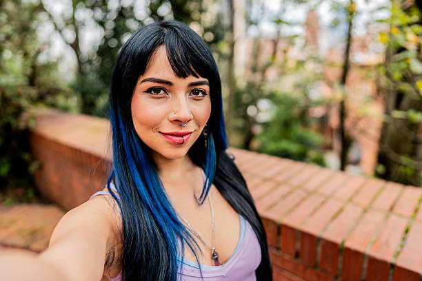 Young LGBTQIA+ woman taking a selfie outdoors - Camera point of view