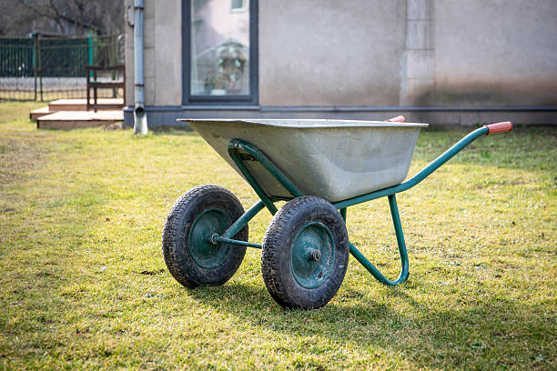 istock Wheelbarrow on Green Lawn with Modern Building in Background 2226177725