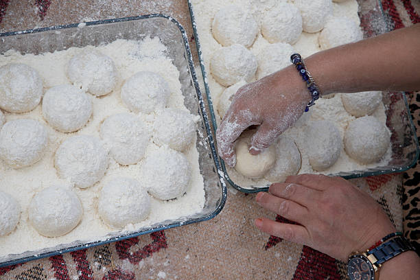 Hand-rolling dough balls with flour – traditional dough preparation by hand.