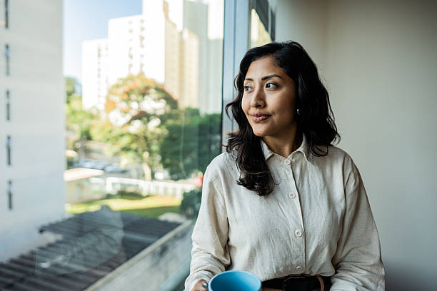 Young woman looking through window at office