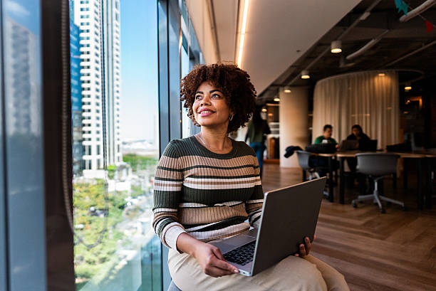 Mature businesswoman contemplating while using laptop at office