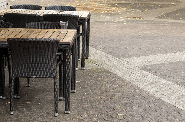 istock Empty tables and chairs standing outside a restaurant on a cobblestone street 2226179761