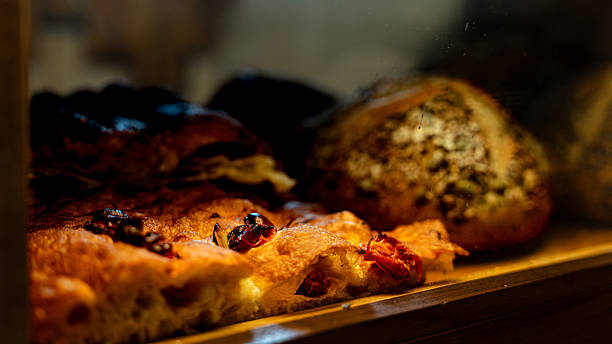 Delicious focaccia bread with dried tomatoes displayed in bakery window