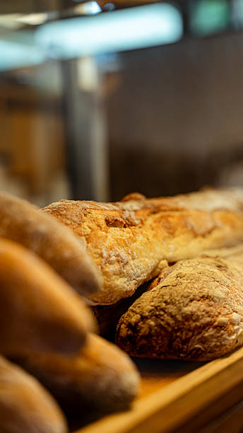 Freshly baked bread displayed on wooden shelf in bakery