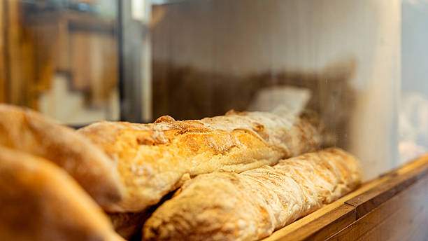 Freshly baked baguettes resting in a bakery display case