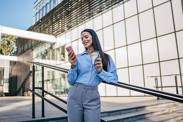 istock Businesswoman using smartphone and drinking coffee outdoors 2226189357