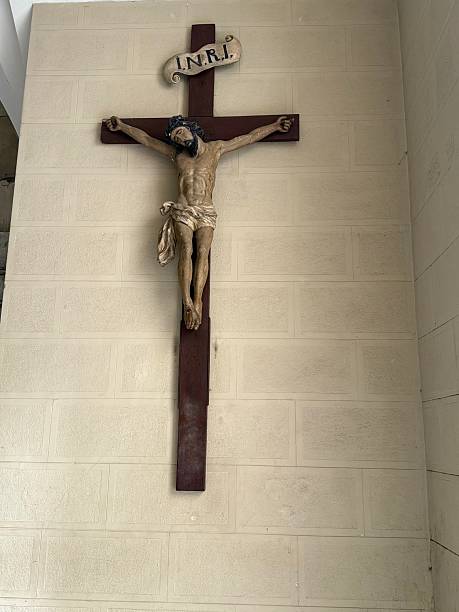 istock Wooden crucifix hanging on a white brick wall representing jesus christ 2226189785