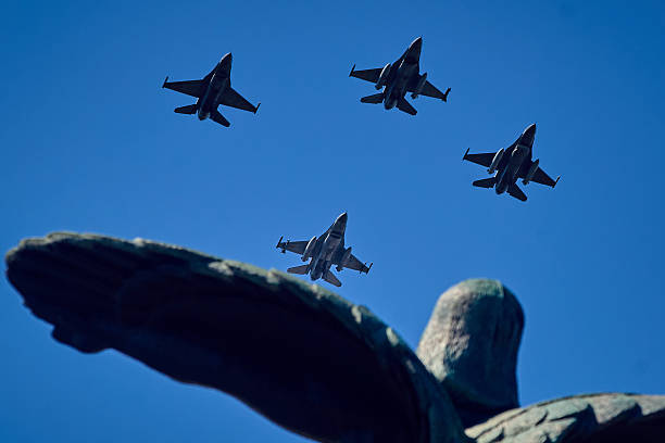 Bucharest, Romania. 20th July, 2025: Four F-16 Fighting Falcons fly in formation over the Air Heroes Monument during the Romanian Aviation and Air Force Day celebration, in Bucharest. The Heroes of the Air Monument is located in the center of Aviators' Square in Bucharest. It commemorates Romanian military and civilian aviators who contributed to the development of aviation. The monument was built between 1928 and 1935 by sculptors Lidia Kotzebue and Iosif Fekete.