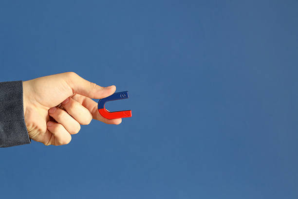 istock Man holding horseshoe magnet on blue background, closeup. Space for text 2226193607