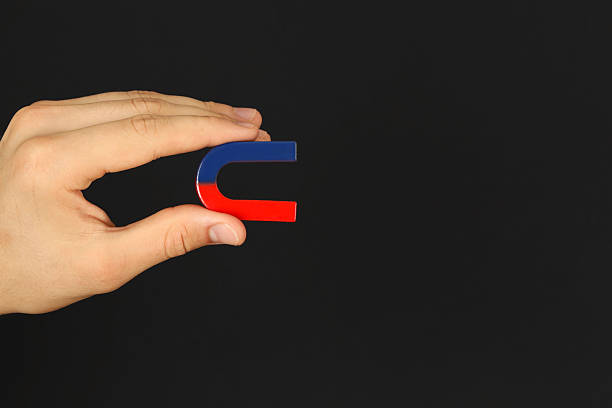 istock Man holding horseshoe magnet on dark background, closeup. Space for text 2226193626