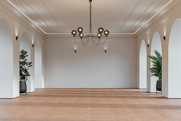 istock Modern empty interior with elegant arched openings, decorative ceiling molding, chandelier and decorative potted plants on orange ceramic floor 2226194800
