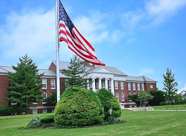 istock Classical style school building with large American flag on front lawn 2226200274