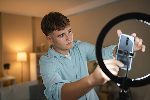 istock man v-logger set up mobile phone and ring light for live streaming 2226201128