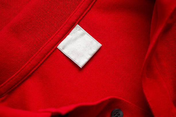 istock Blank white laundry care clothes label on red shirt fabric texture background 2226212915