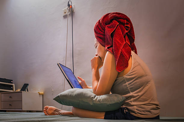 istock Woman browsing tablet in bedroom with towel on head 2226217508
