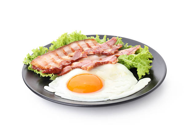 Fried eggs with bacon on a blue background close-up