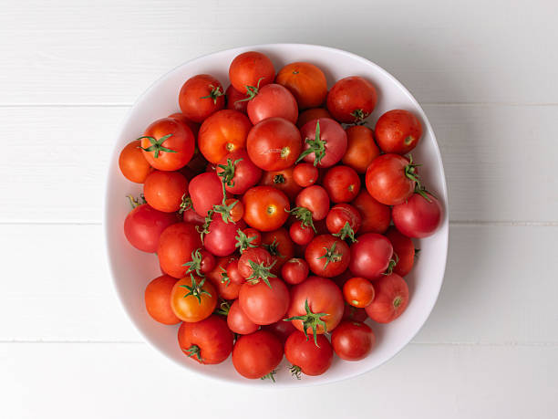 istock Fresh Organic Tomatoes in White Bowl on Wooden Surface 2226225671
