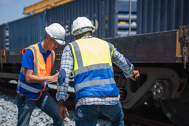 istock Engineers Checking Cargo Train Wheel and Undercarriage, Railroad Workers Inspecting Tank Cars on Tracks, Industrial Team Conducting Maintenance on Freight Train 2226231655