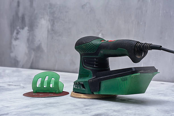 istock Closeup of green electric orbital sander on marble surface with sanding disk. Construction tool for renovation. 2226242891