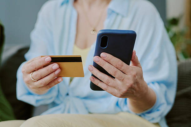 istock Caucasian Middle Aged Woman Holding Credit Card While Using Smartphone 2226243906