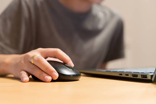 istock Close up hand using mouse with laptop on wooden table for working from home, remote office or freelance concept 2226243998