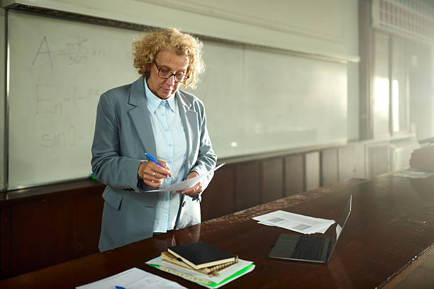 istock Female professor grading exams in a lecture hall. 2226245495